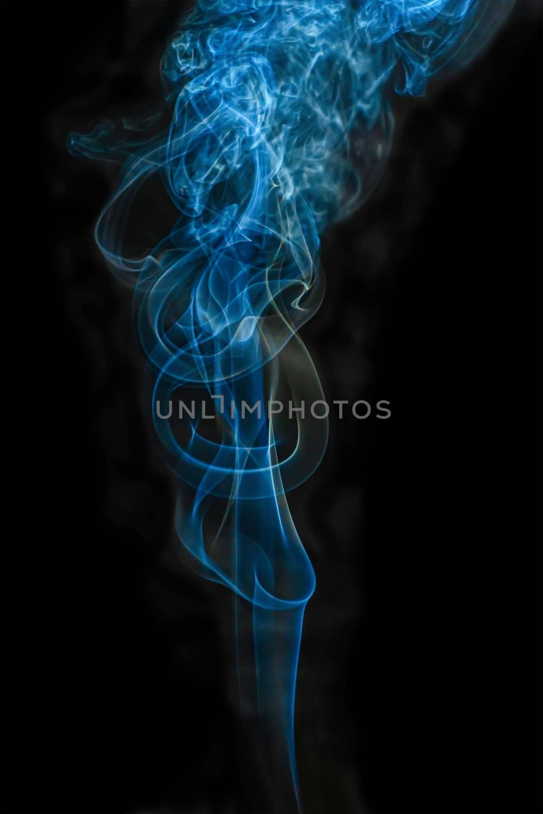 The steam color smoke of in movement on a black background. It is abstract.
