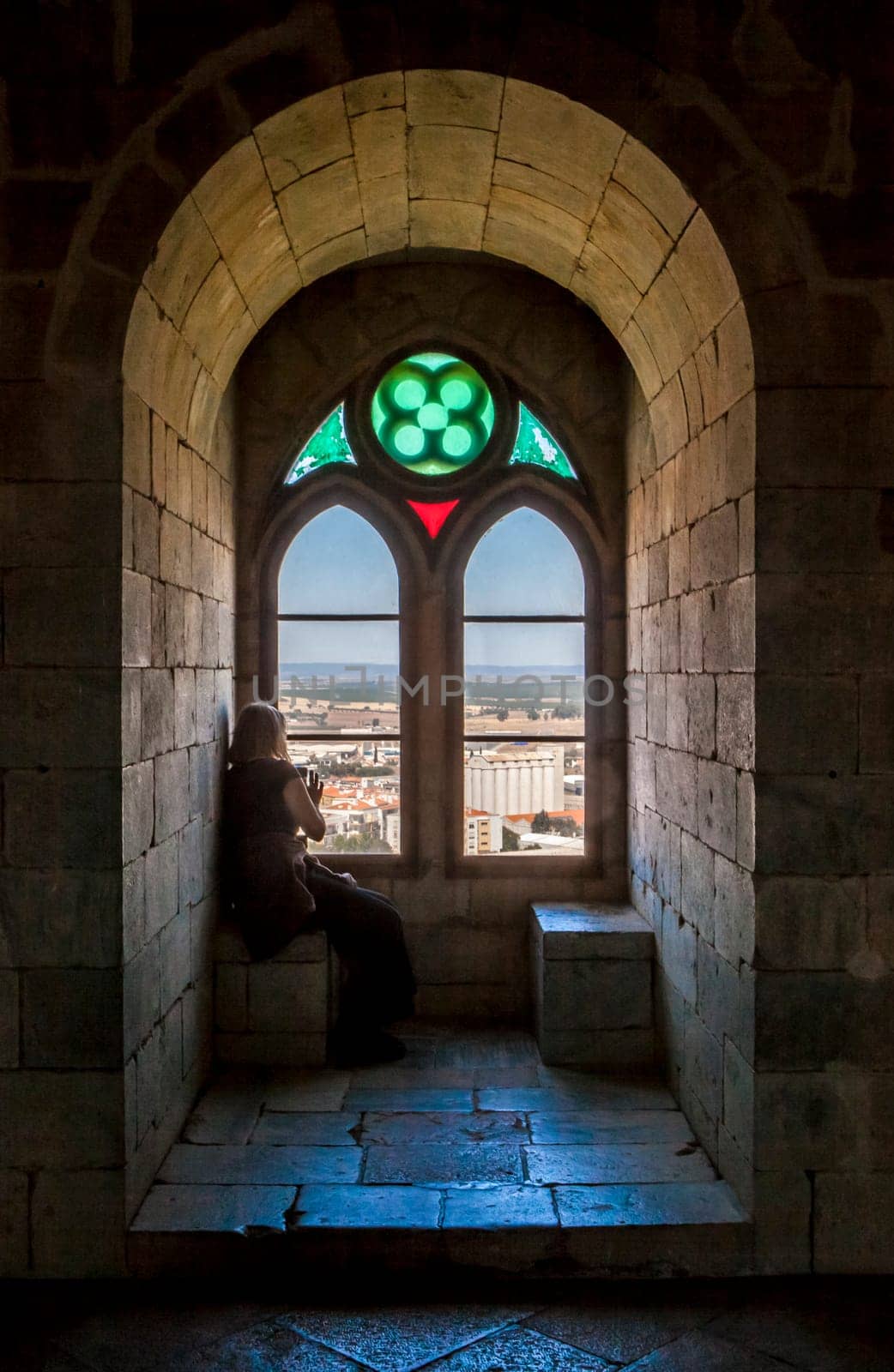 Beja, Portugal - Jul 27th, 2023: Visitors sitting beside interior window bench of the fortress. Beja Castle, Baixo Alentejo, Portugal