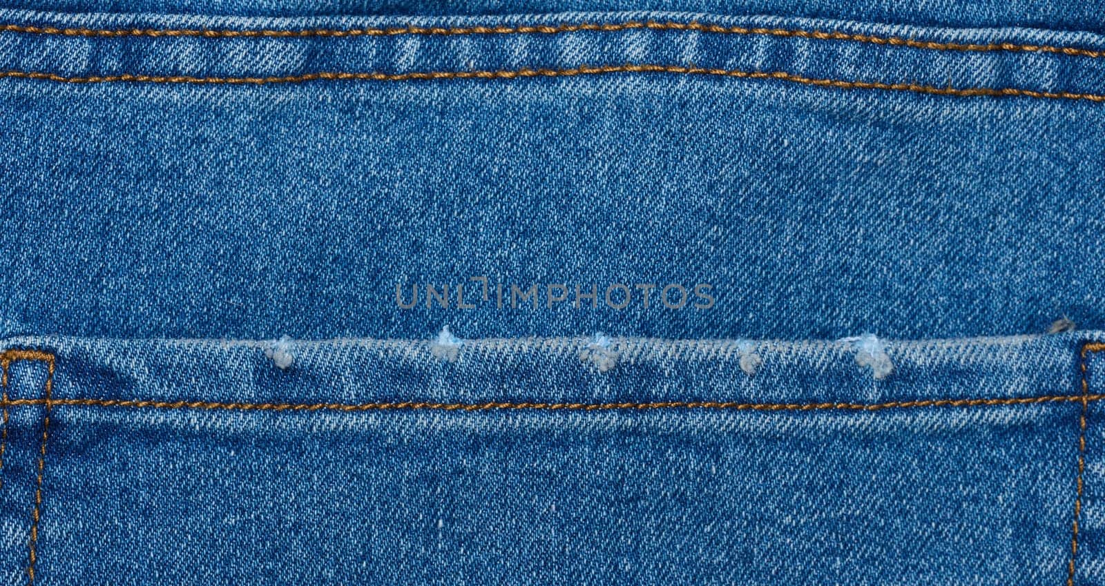 Fragment of the back pocket of blue jeans