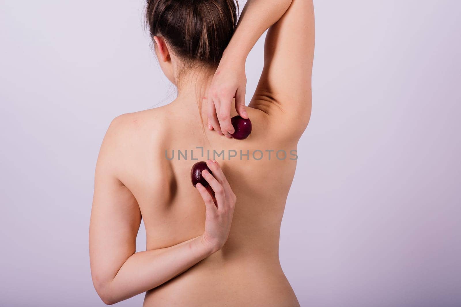 Topless woman with an onion on white background