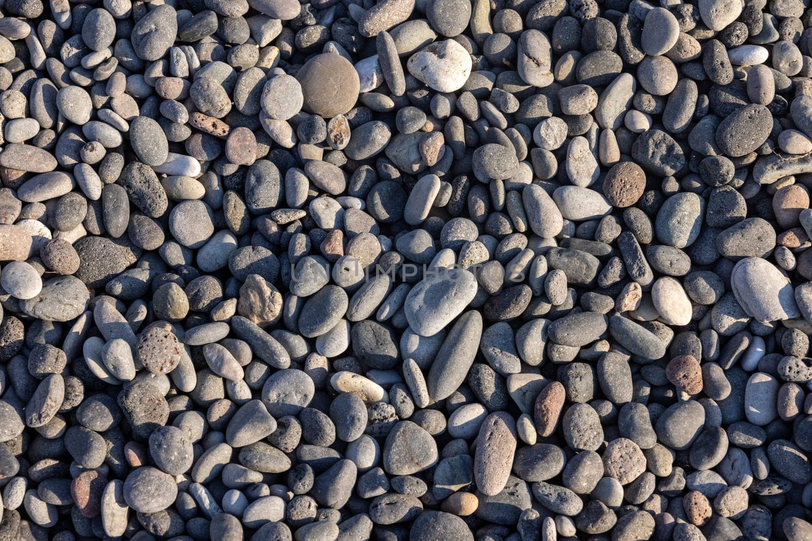 Background of sea stones. Close-up of stones of different shapes and sizes on the beach