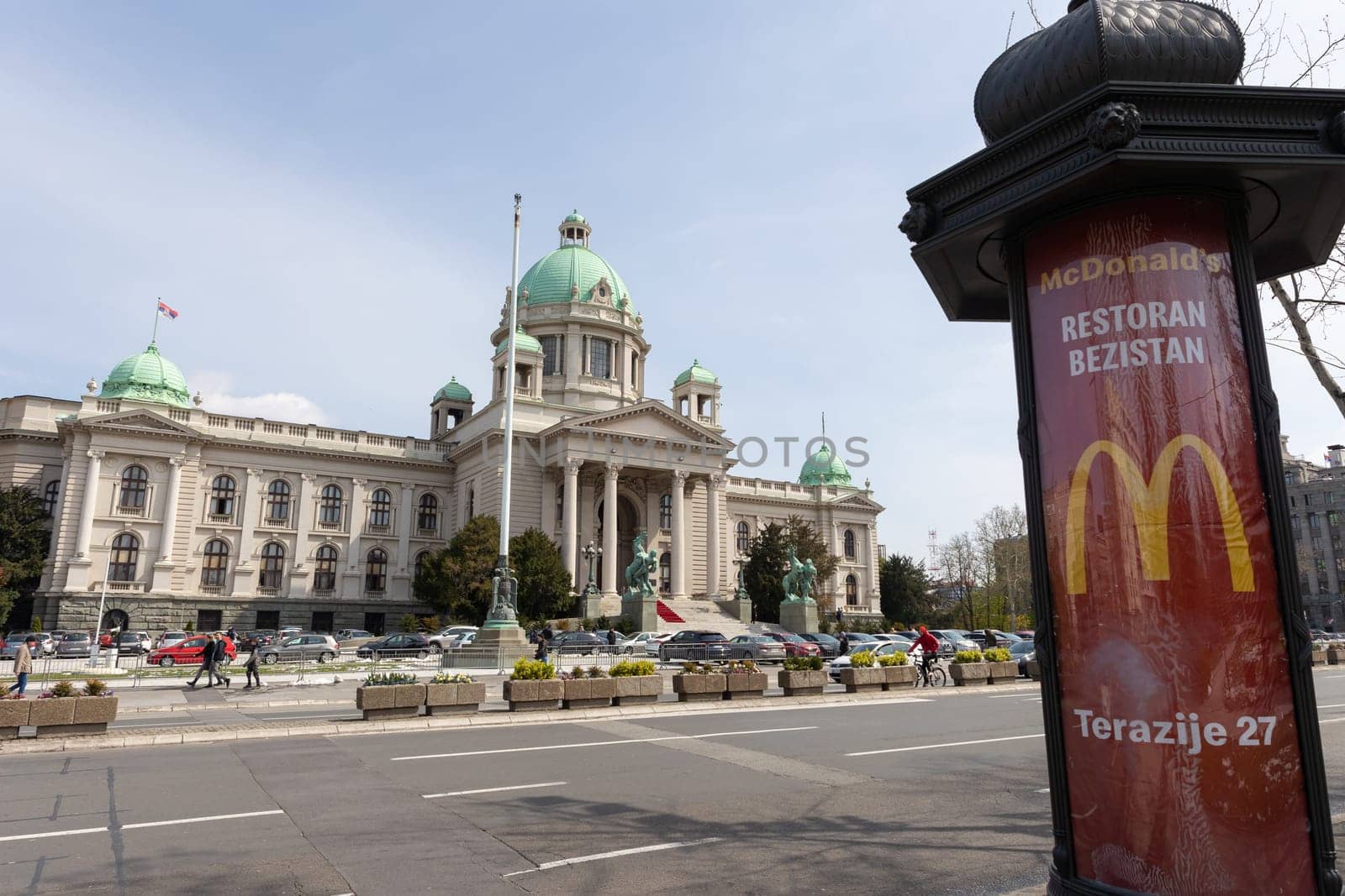 5 April 2023 Belgrade, Serbia: serbian parliament building and mcdonalds signboard on the foreground. Mid shot