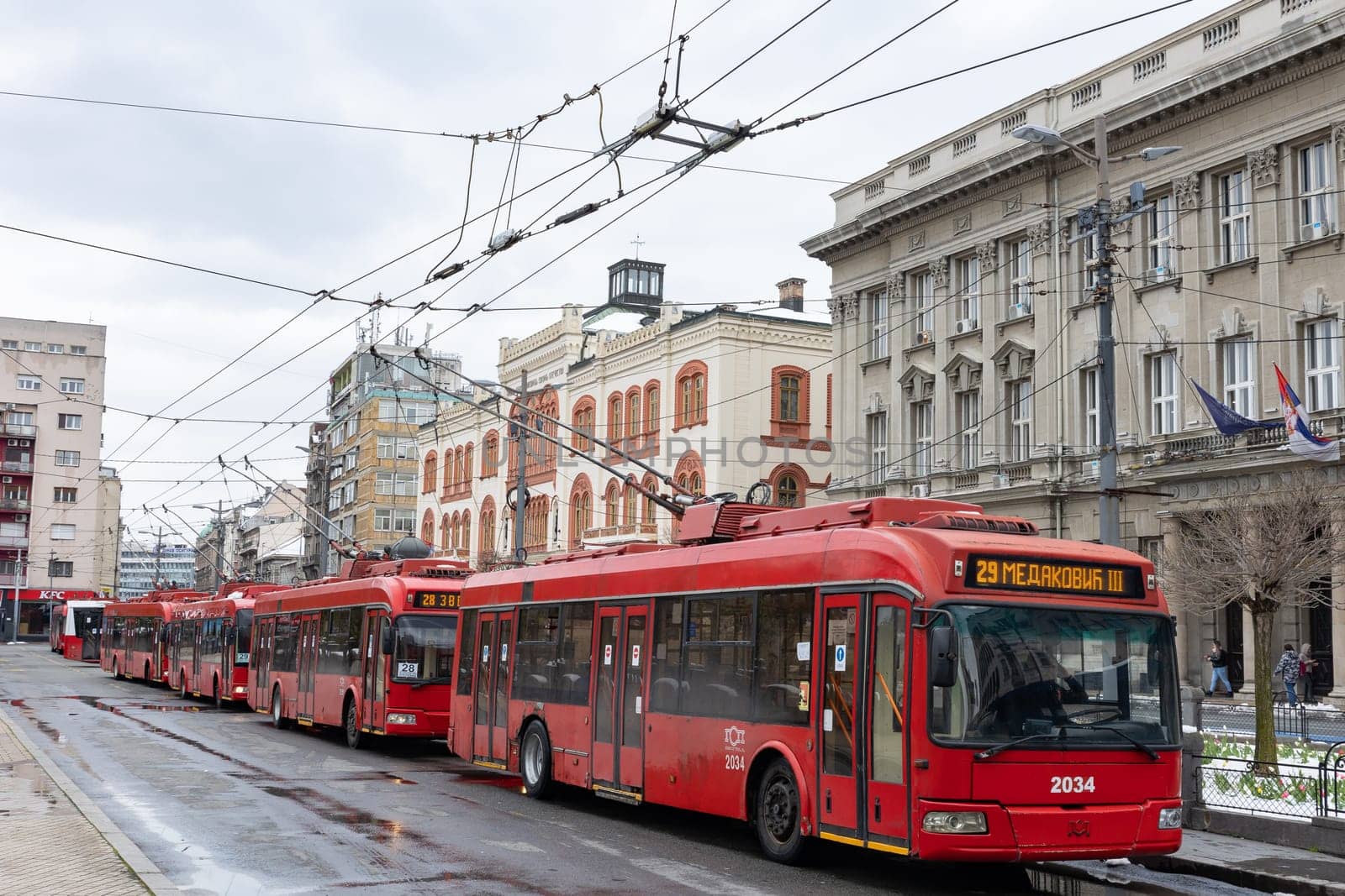 5 April 2023 Belgrade, Serbia: red trolleybuses at the stop. Mid shot