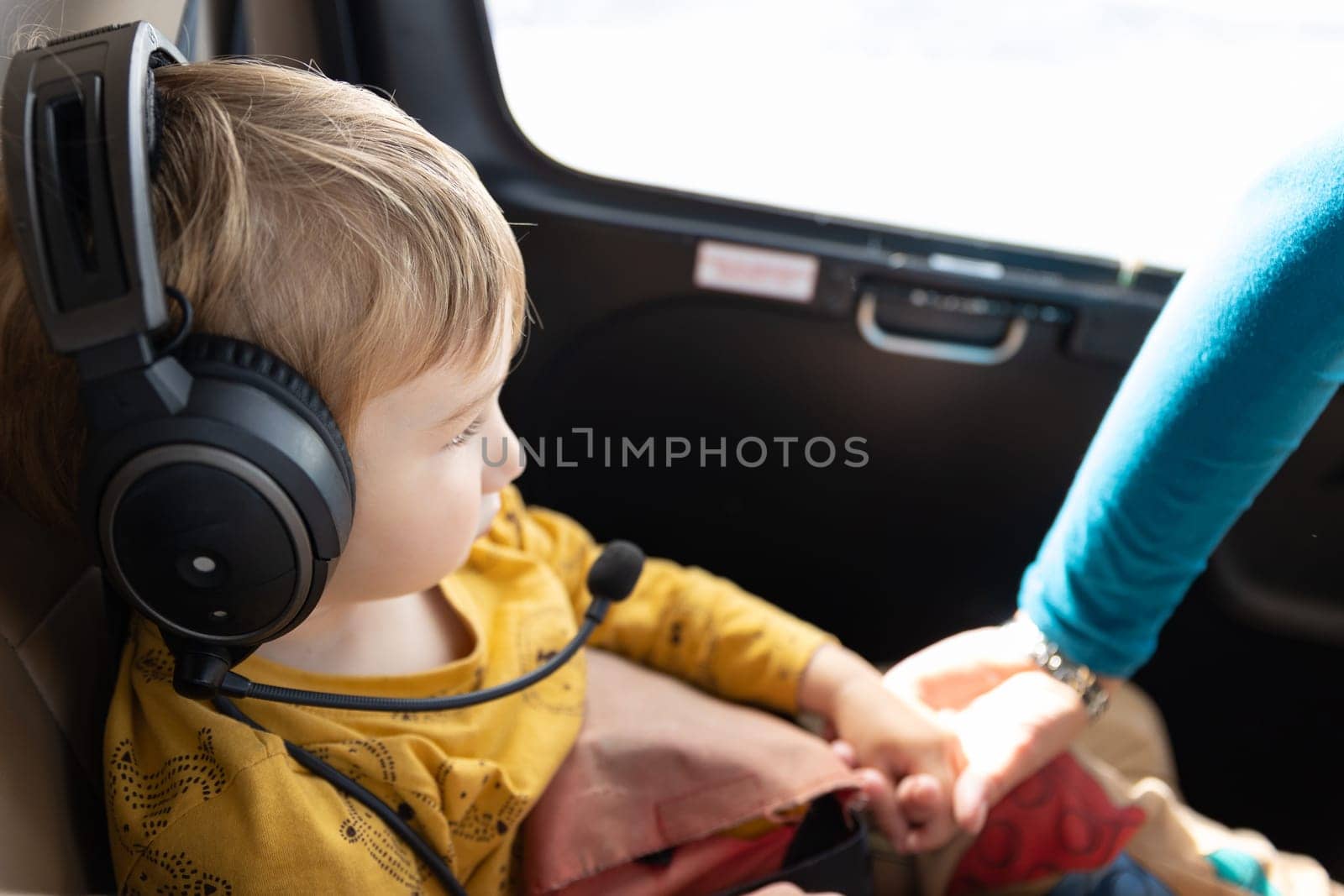 A little boy in helicopter wearing headphones. Mid shot