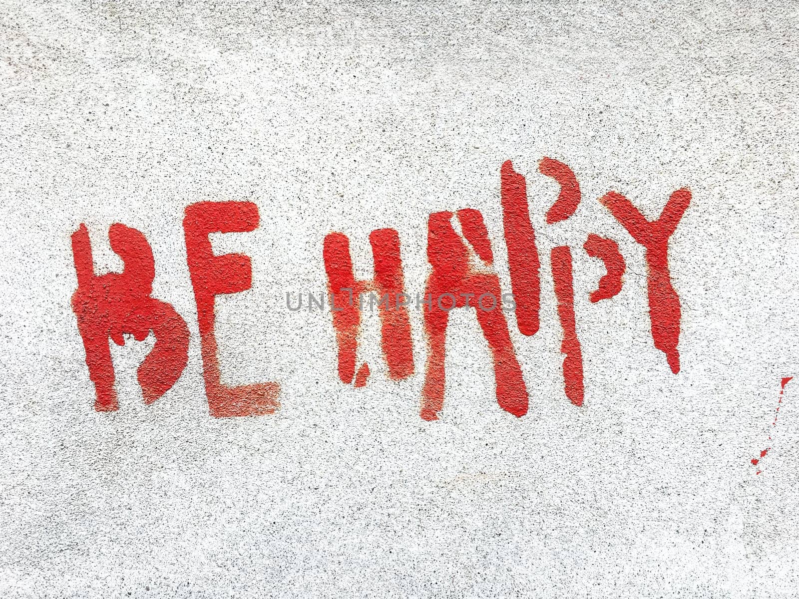 Be happy written in graffiti style with rough texture isolated on gray background.