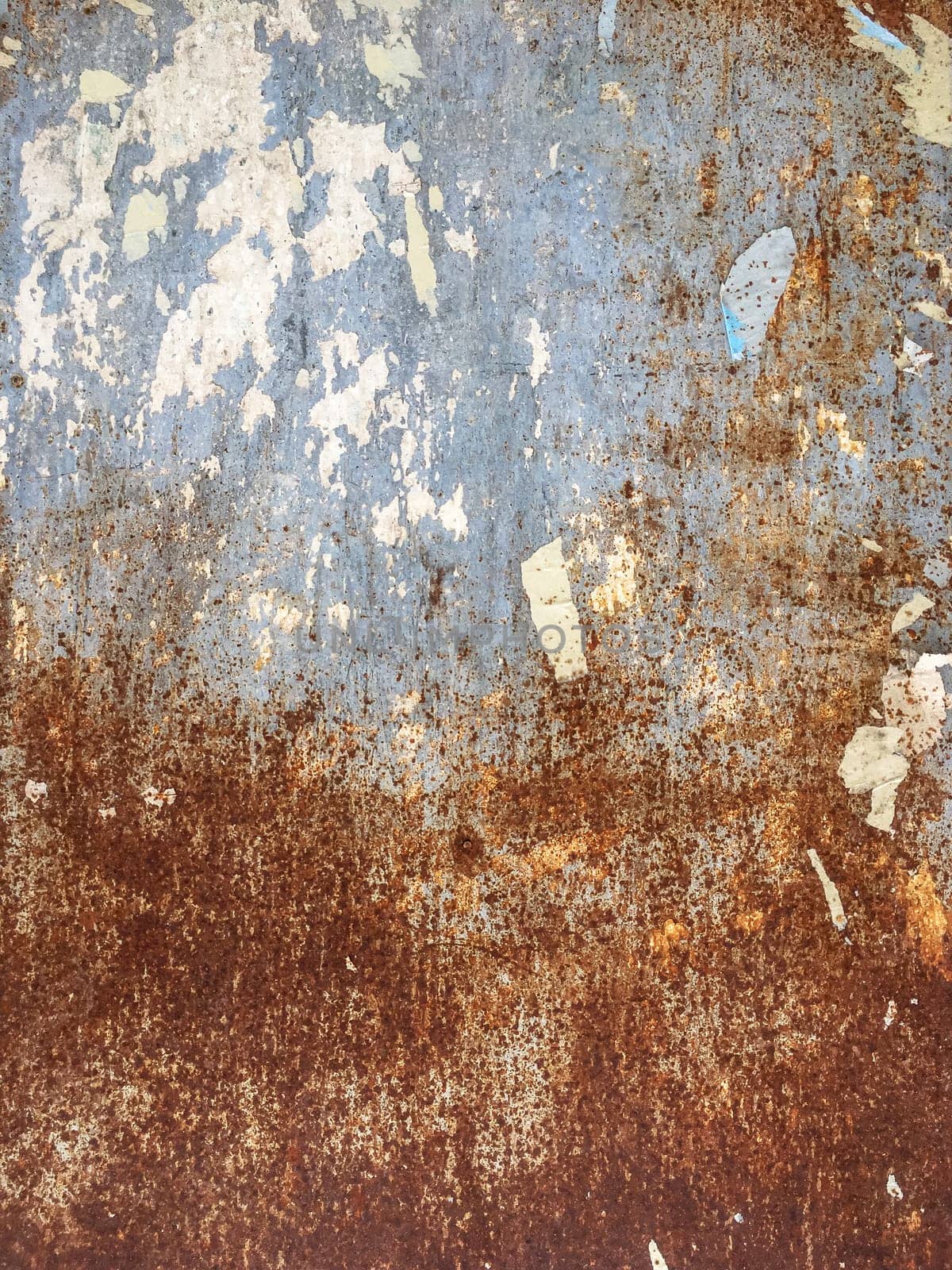 Rusty metal background with torn poster pieces. Ideal for concepts and textures.