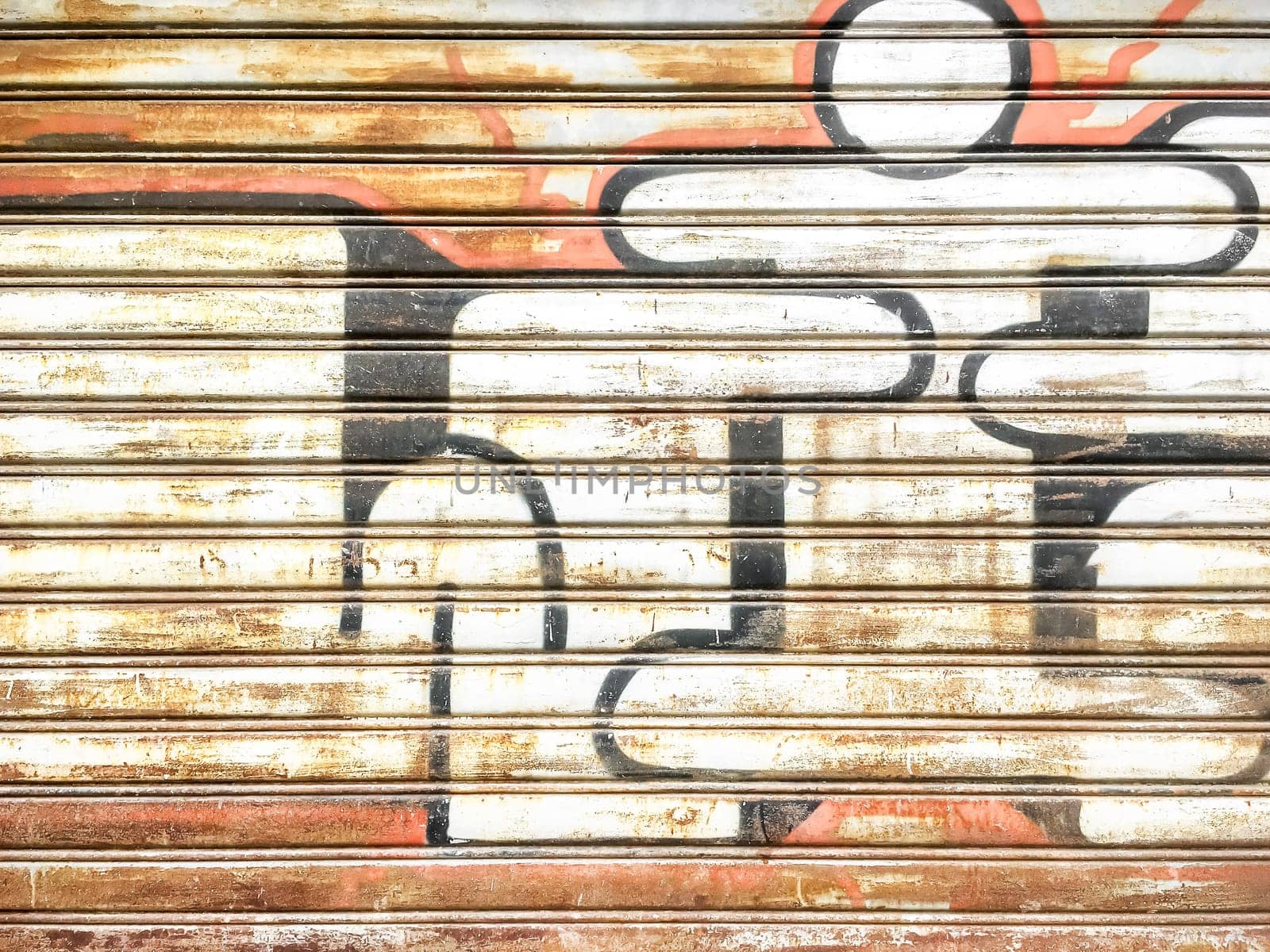 Spray painted graffiti on metal rusted shutters. Urban.