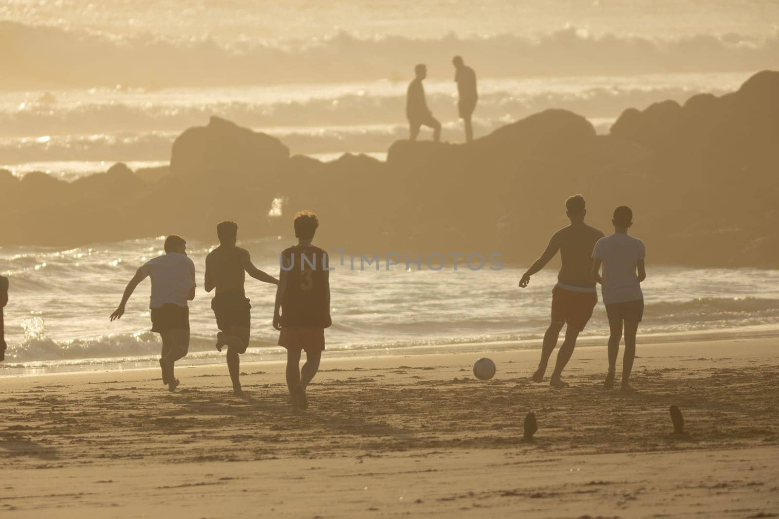 19 April 2023 Lisbon, Portugal: Costa da Caparica - young men playing with a ball on the beach. Mid shot