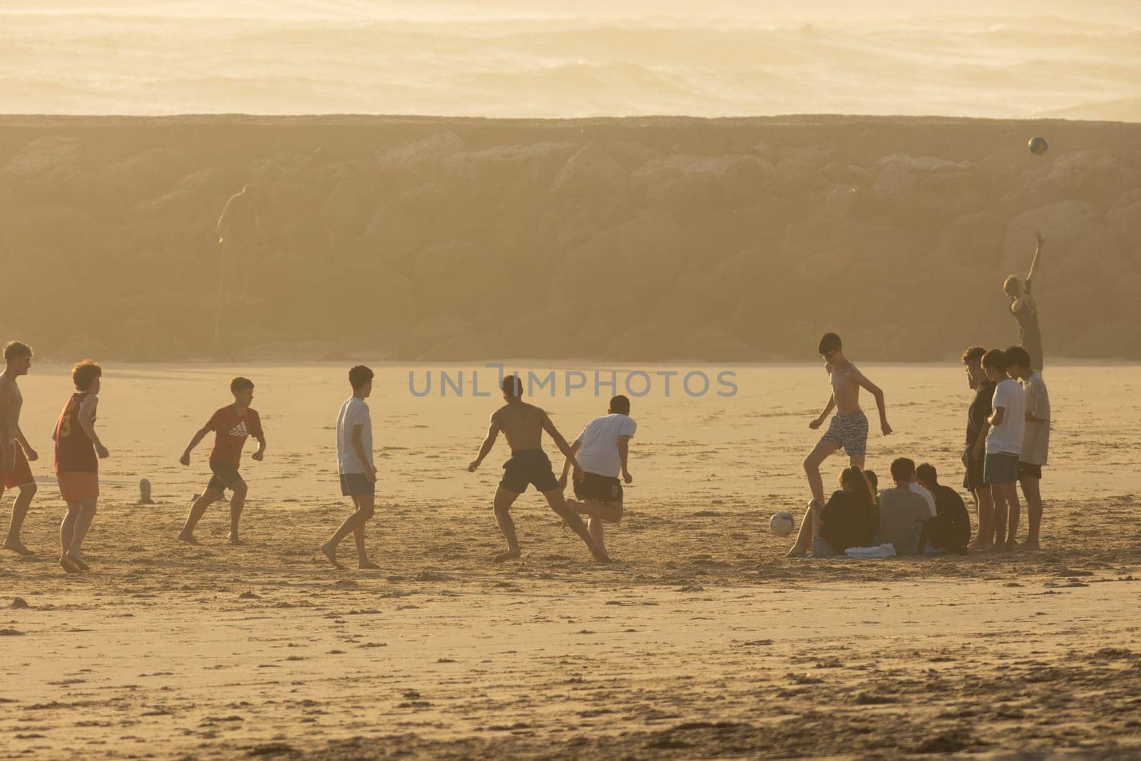 19 April 2023 Lisbon, Portugal: Costa da Caparica - young guys playing with a ball on the beach. Mid shot