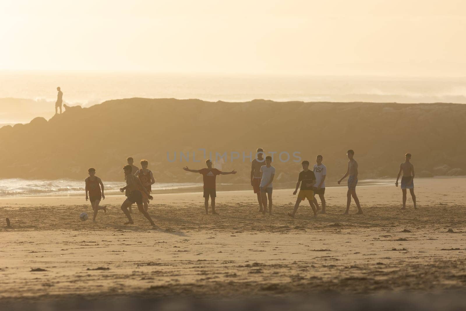 19 April 2023 Lisbon, Portugal: Costa da Caparica - young men playing soccer on the beach. Mid shot