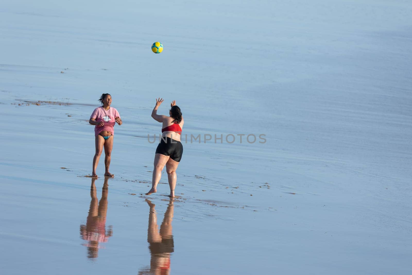 19 April 2023 Lisbon, Portugal: Costa da Caparica - two women playing with ball on the beach. Mid shot