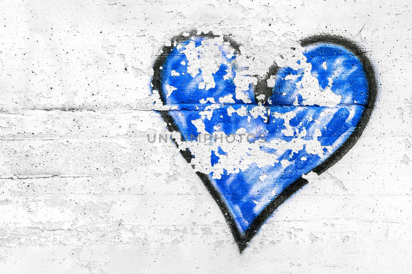 Painted blue abstract heart shape love symbol, dirty wall background, metaphor to urban and romantic valentine, grunge style.