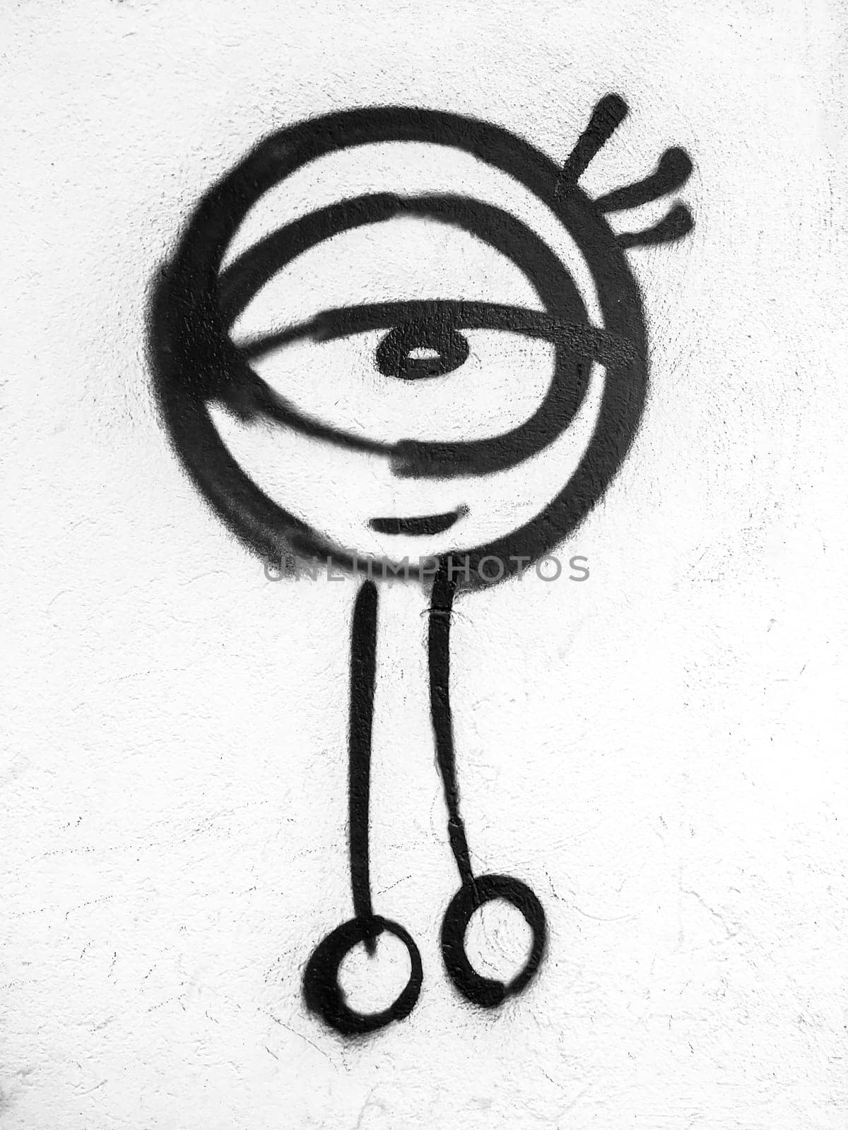 Graffiti on a white exterior wall depicting an alien. Art. Fantasy. Science. Concepts.