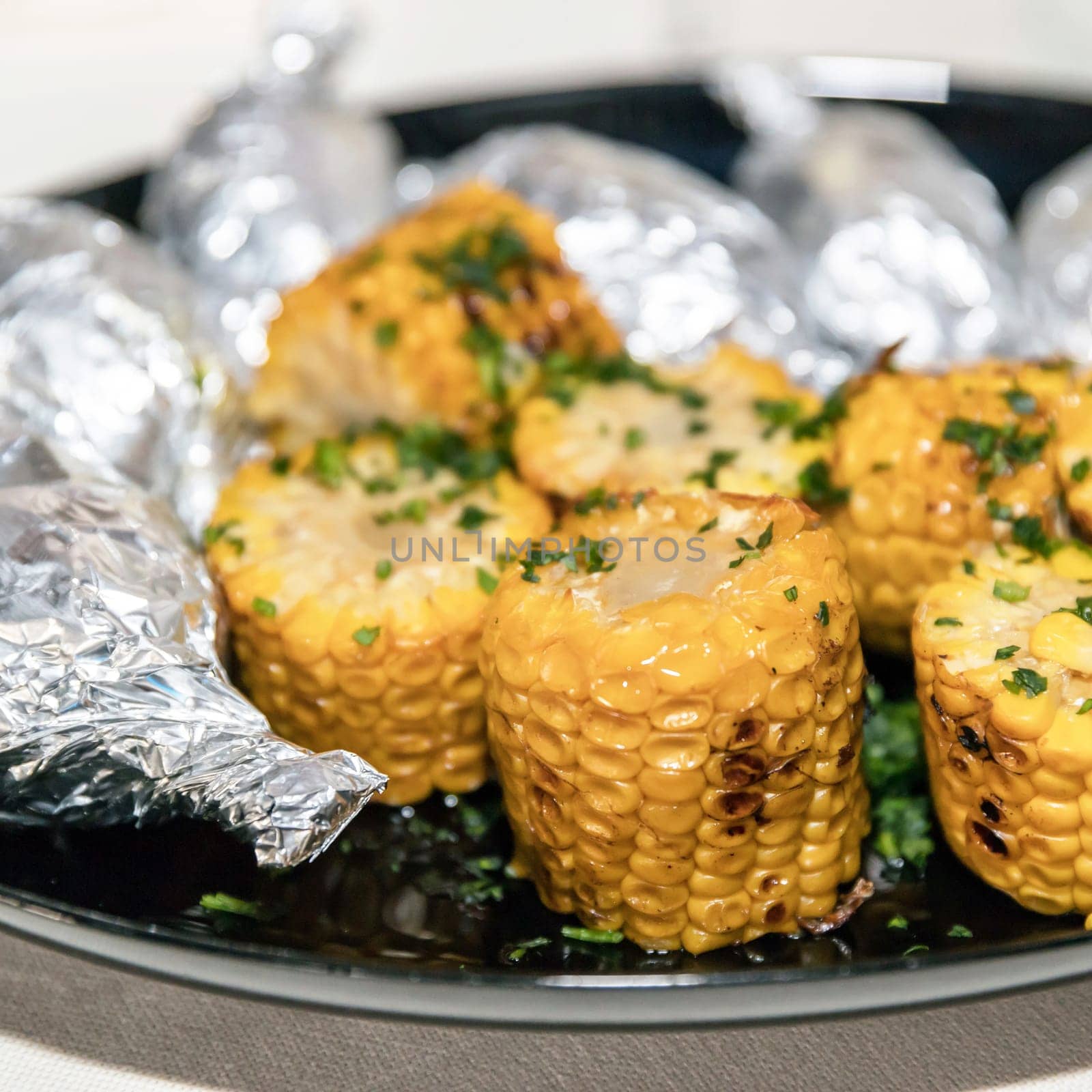 Grilled corn on the cob with green parsley. Tasty dish.
