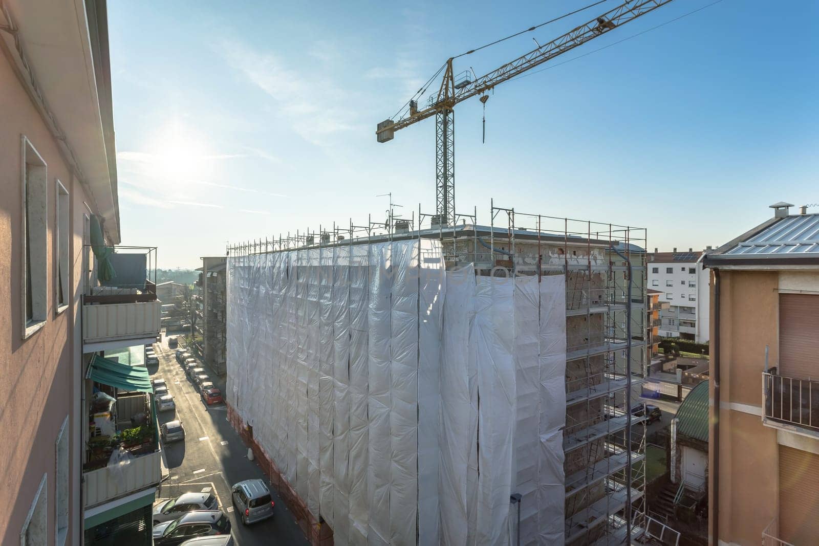 Extensive scaffolding providing platforms for work in progress on a new apartment block, Tall building under construction with scaffolding, New construction site.