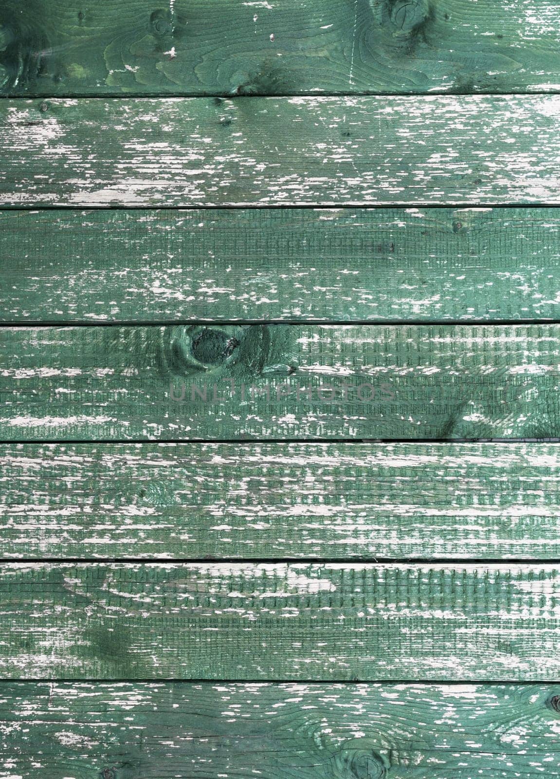 Old green wooden wall with cracked paint, background texture.