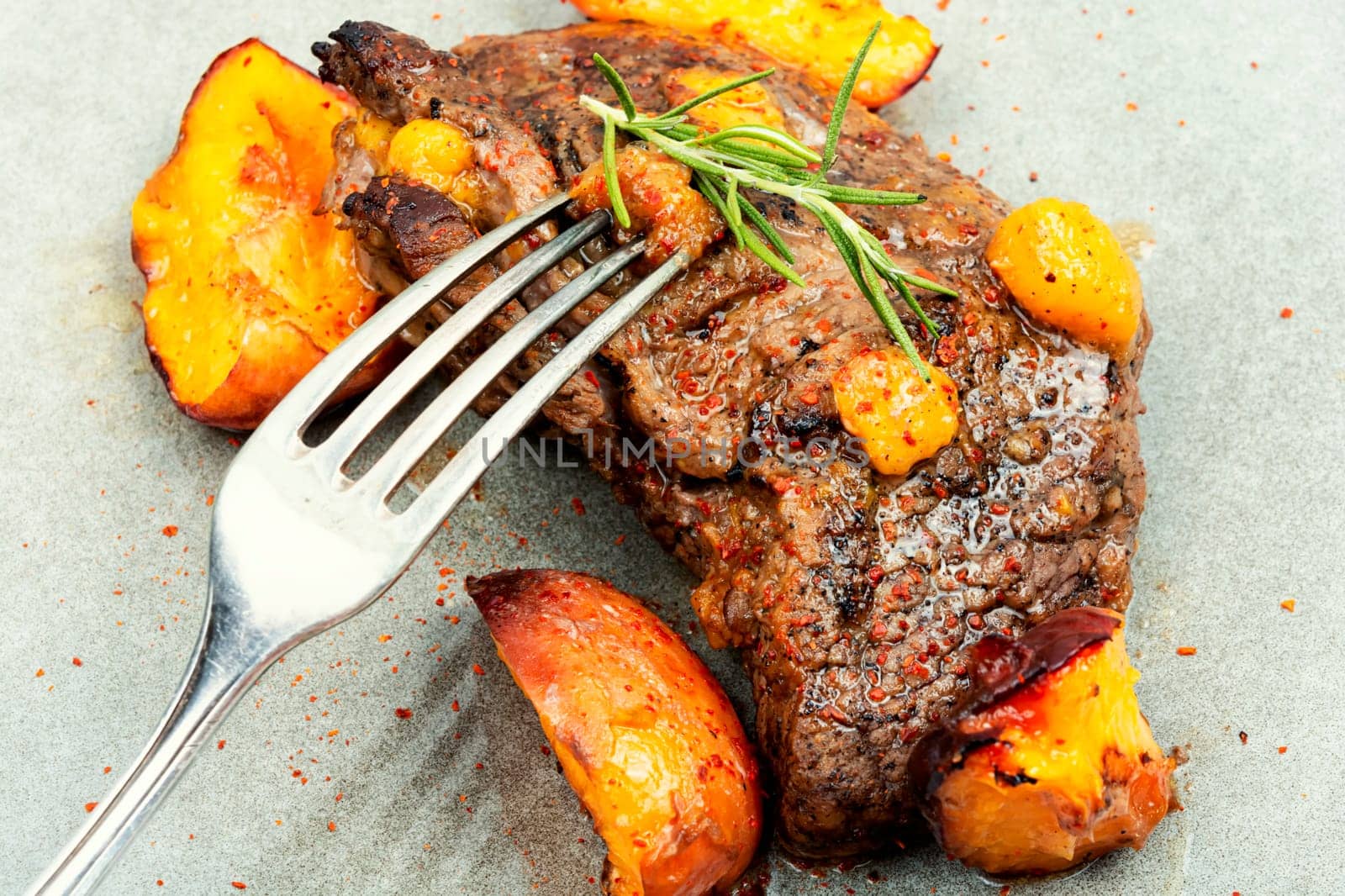 Tasty beef steak with peach in fruit marinade. Close-up.