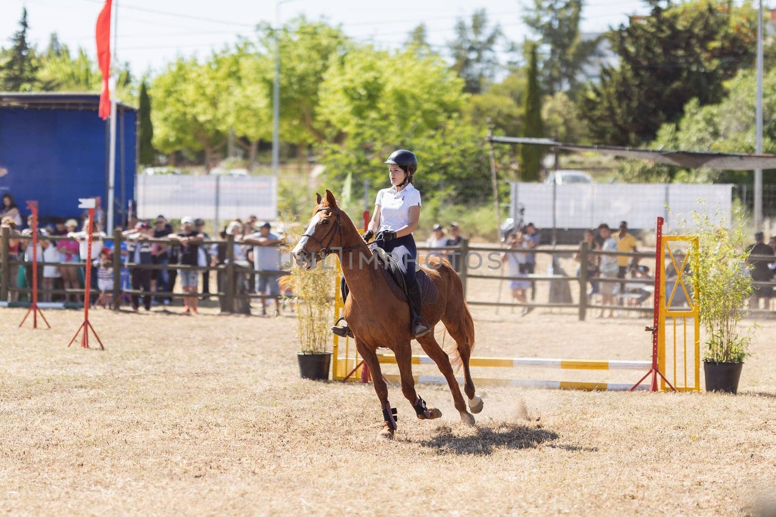 30 april 2023 Sobreda, Portugal: Festival Hipico da Sobreda - a girl riding a brown horse at the ranch. Mid shot