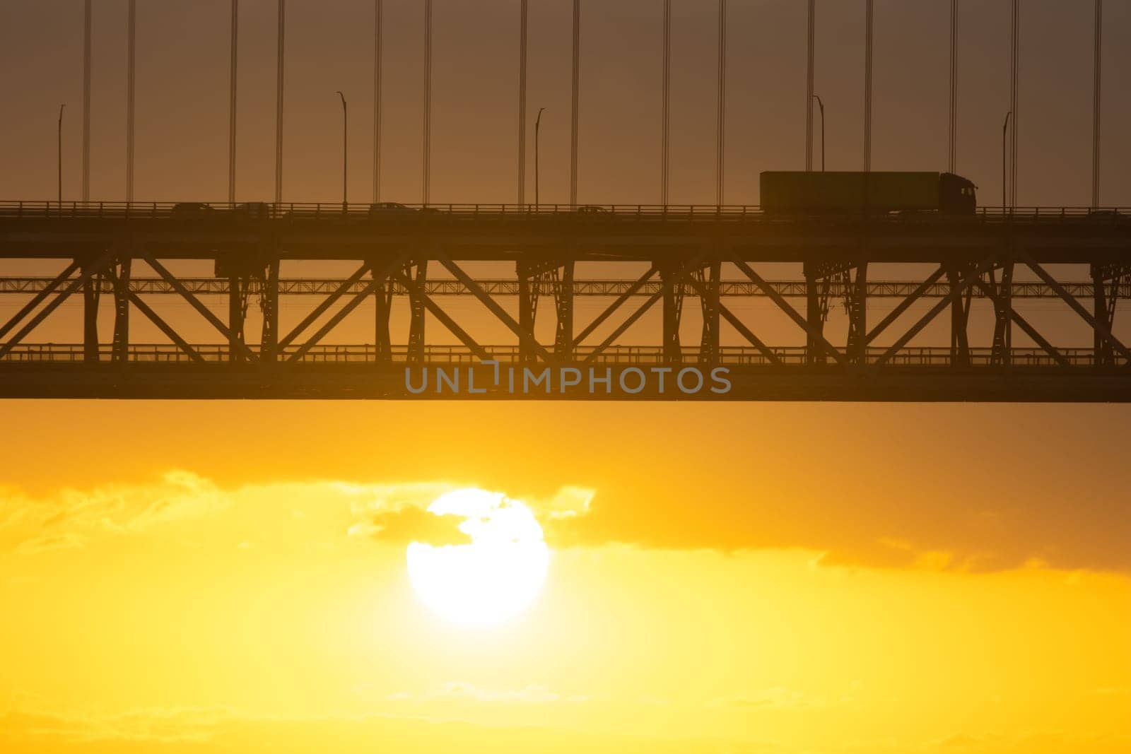 Bridge - Ponte 25 de Abril Lisbon Portugal - 25 april Bridge, cars and tracks moving over the bridge at sunrise or sunset, morning
