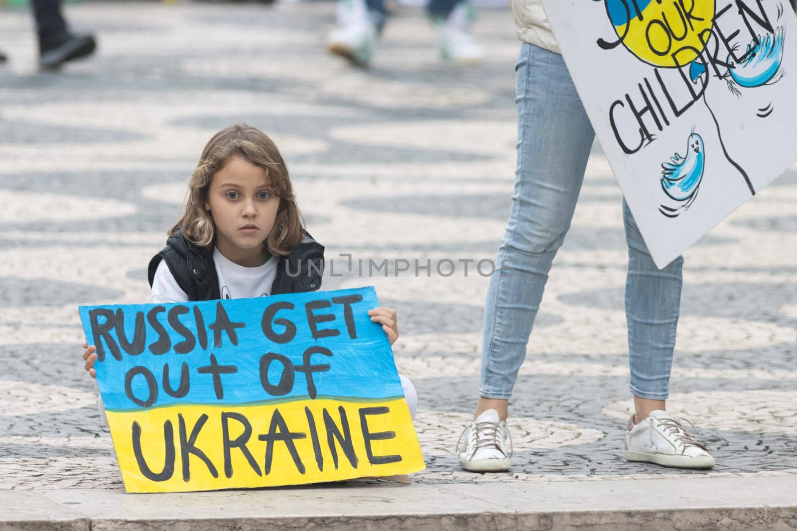 10-29-2022 LISBON, PORTUGAL: Ukrainian protest in Lisbon - little girl holds a poster in support of Ukraine. Mid shot