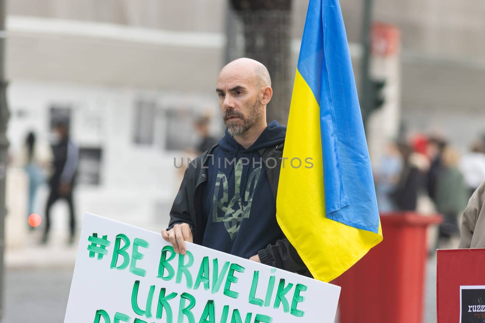 10-29-2022 LISBON, PORTUGAL: Ukrainian protest in Lisbon - a Ukrainian man holds a poster with a hashtag. Mid shot