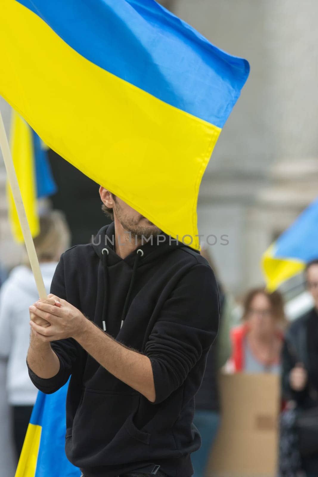 A bearded man hold Ukrainian flag during protest. Vertical shot