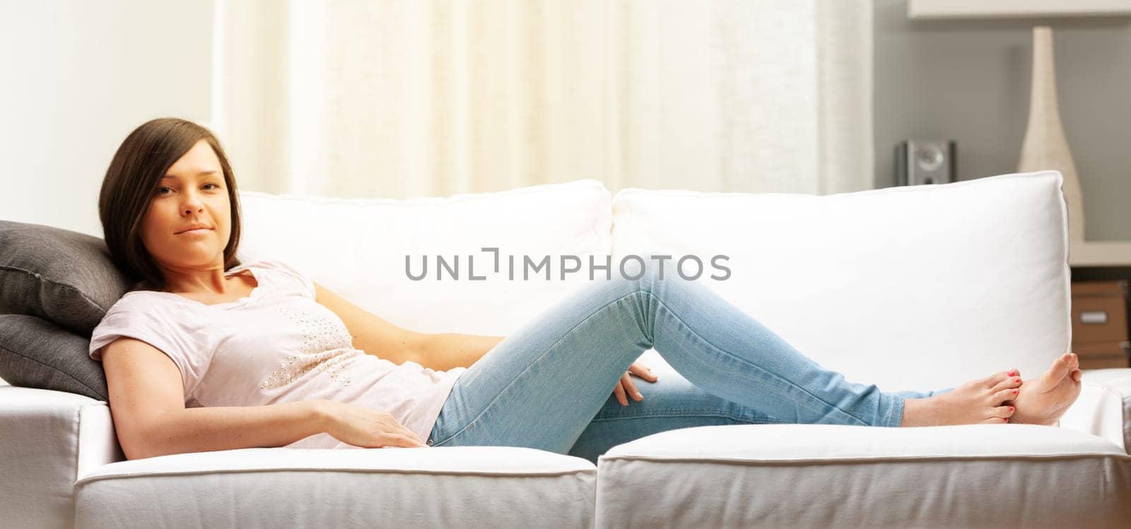 long haired smiling woman on a choush in her living room