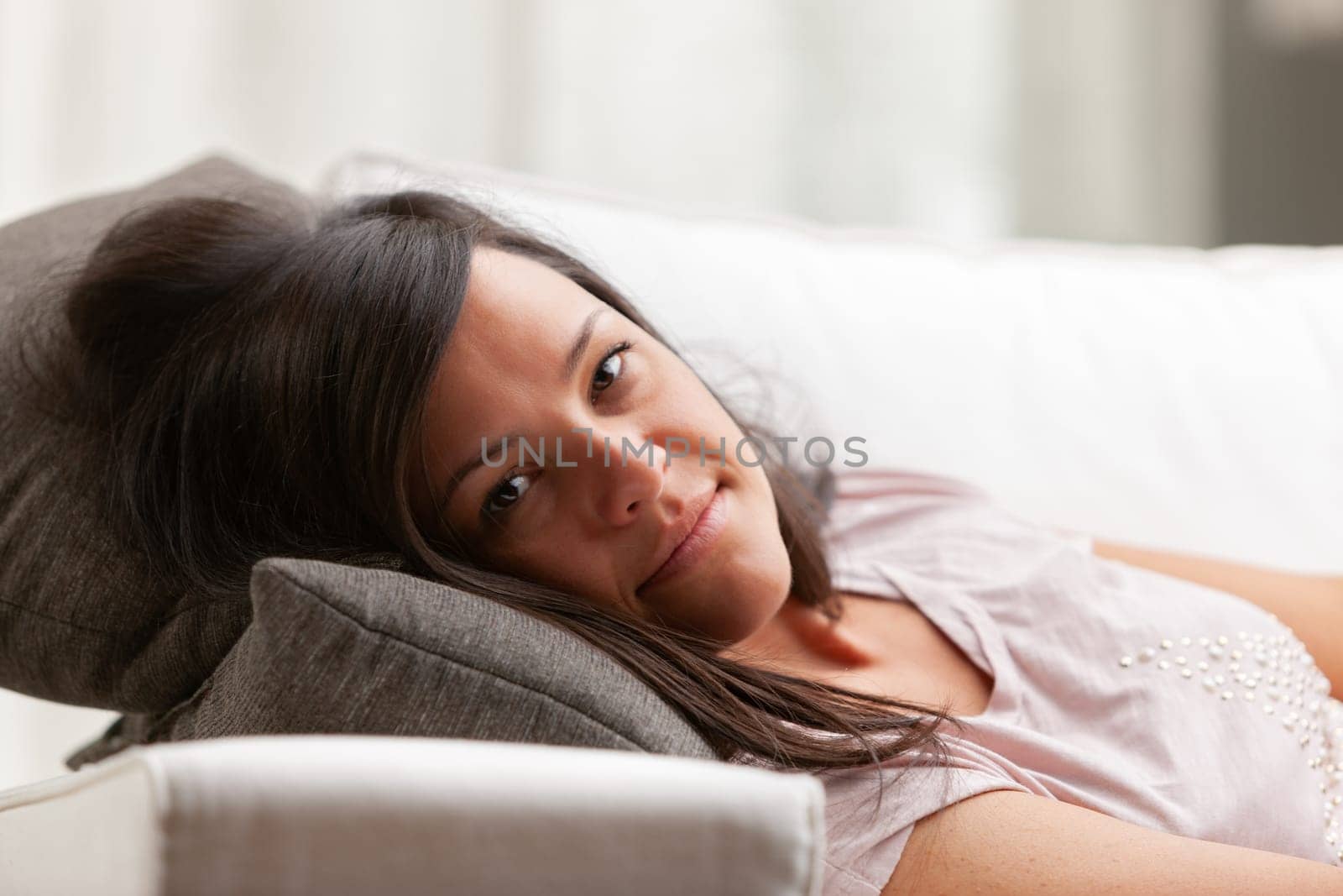long haired smiling woman on a choush in her living room