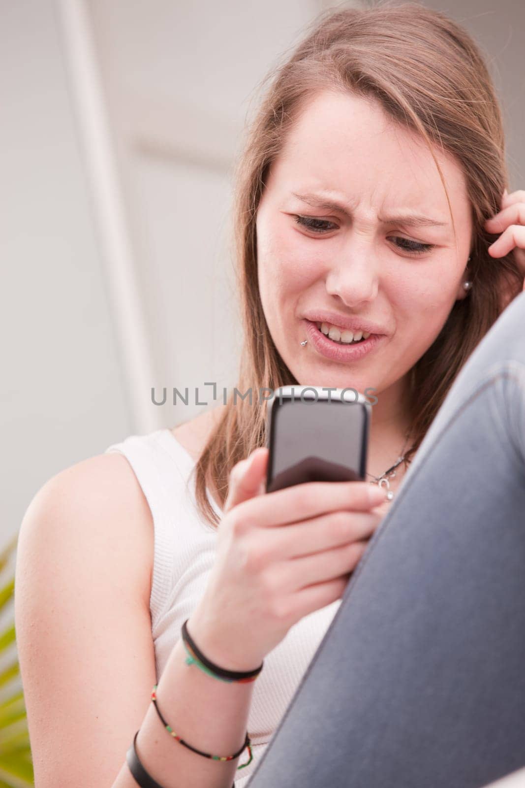 girl upset by something on her mobile phone