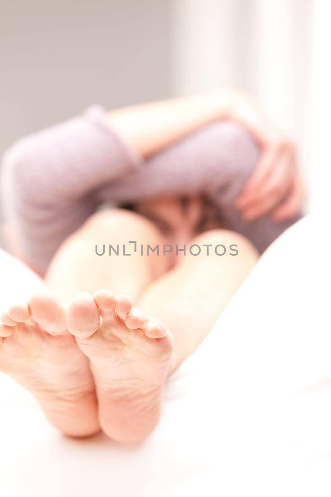 young girl on a sofa in her living room have some problems with her feet