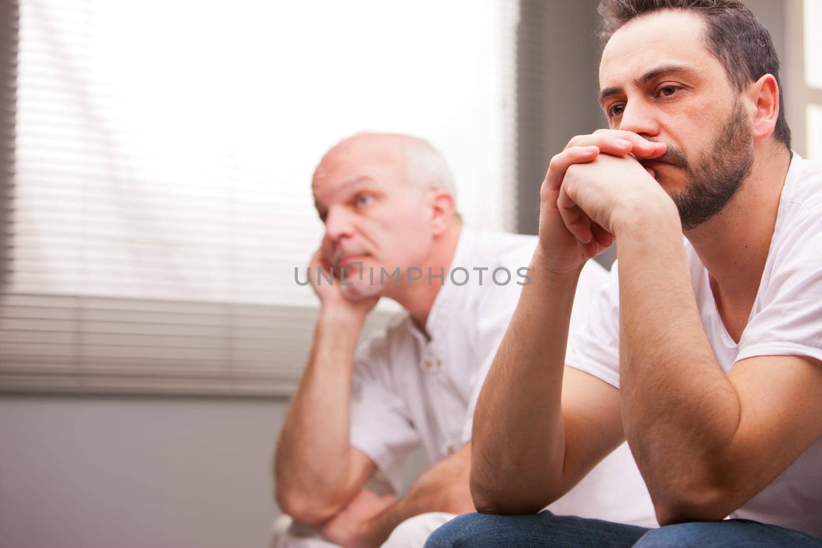 a couple of male friends thinking about something that worries them