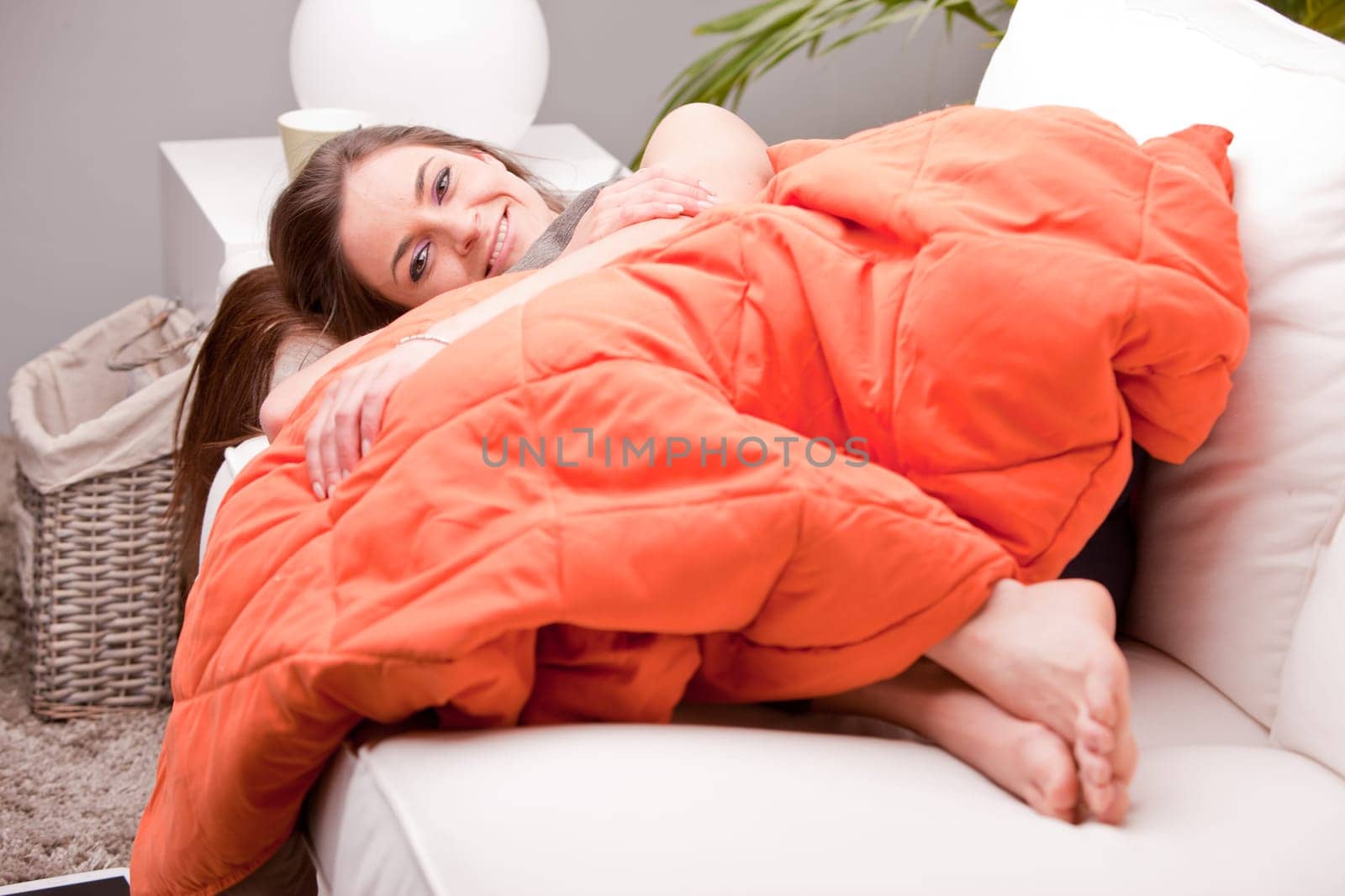 young sexy woman smiling on a couch in her living room happy and relaxed because she's successful