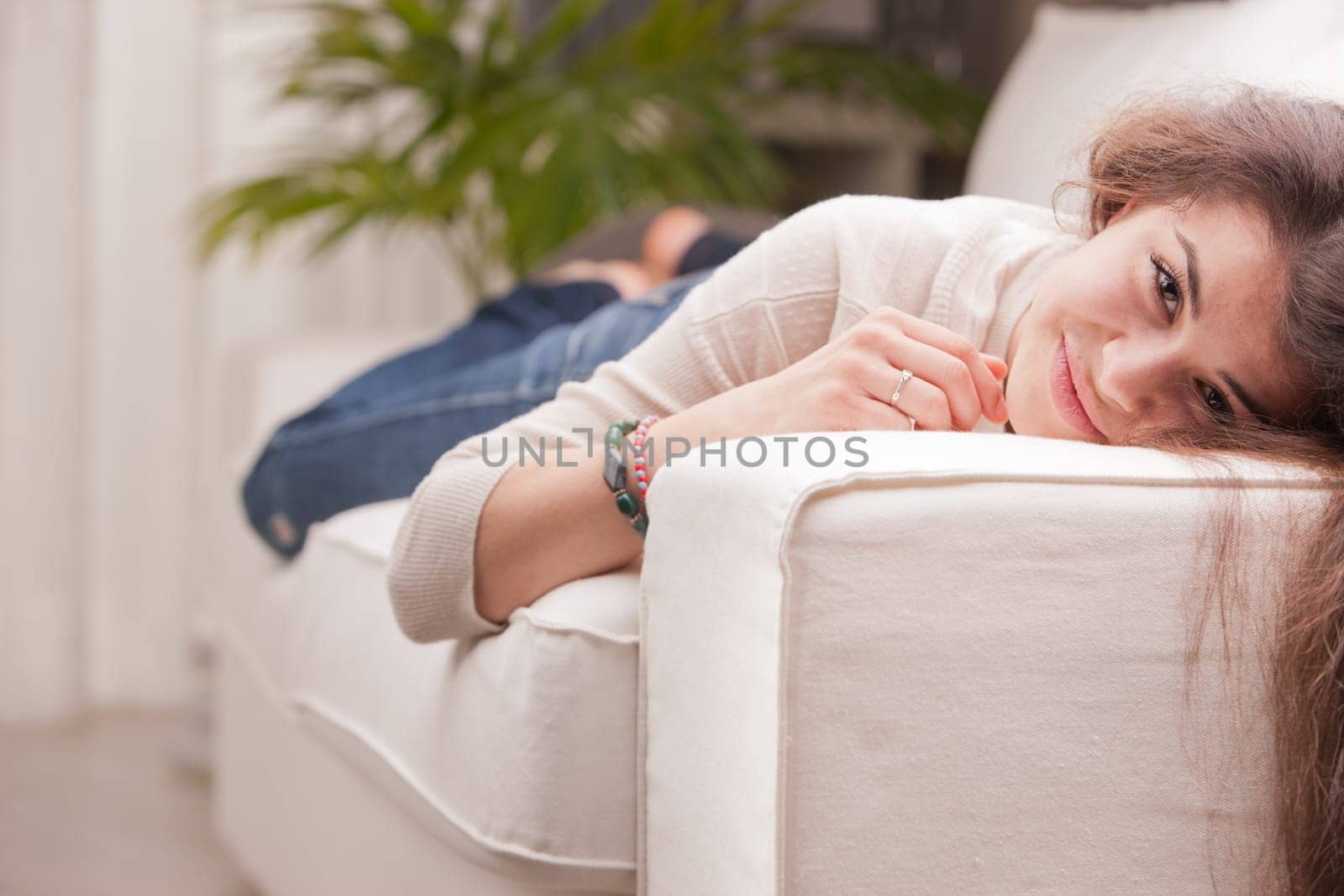 young pretty girl lying on a couch and smiling on her living room because her life is good