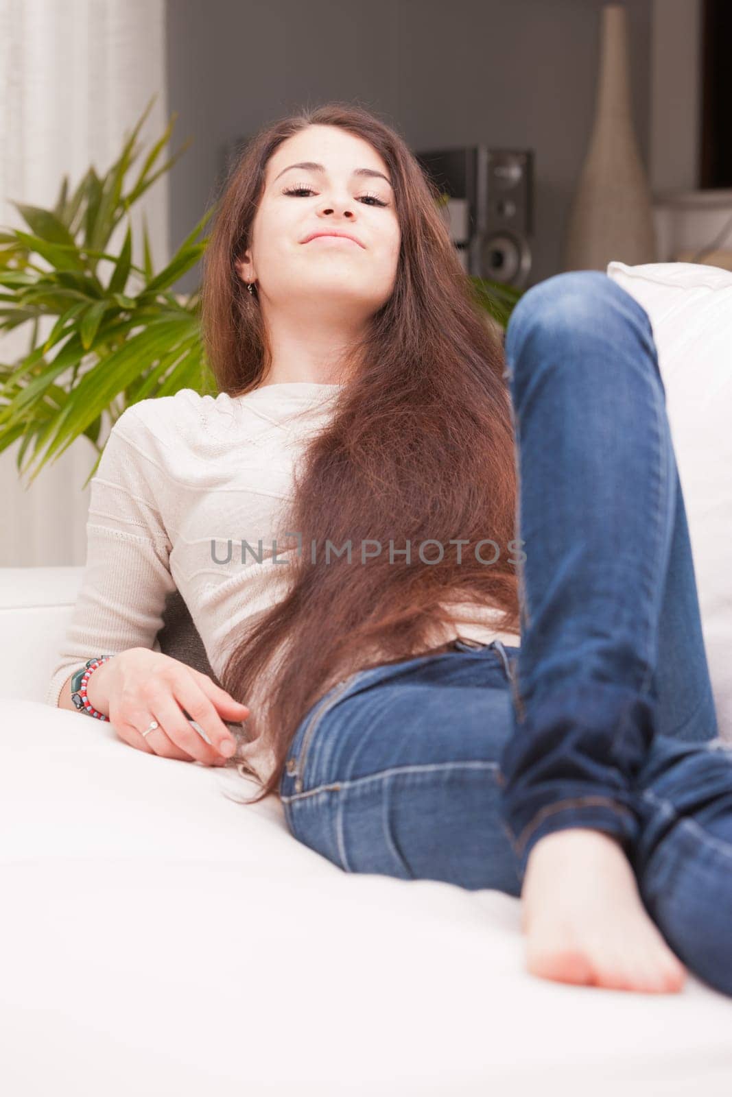 next door girl smiling in her living room on her couch