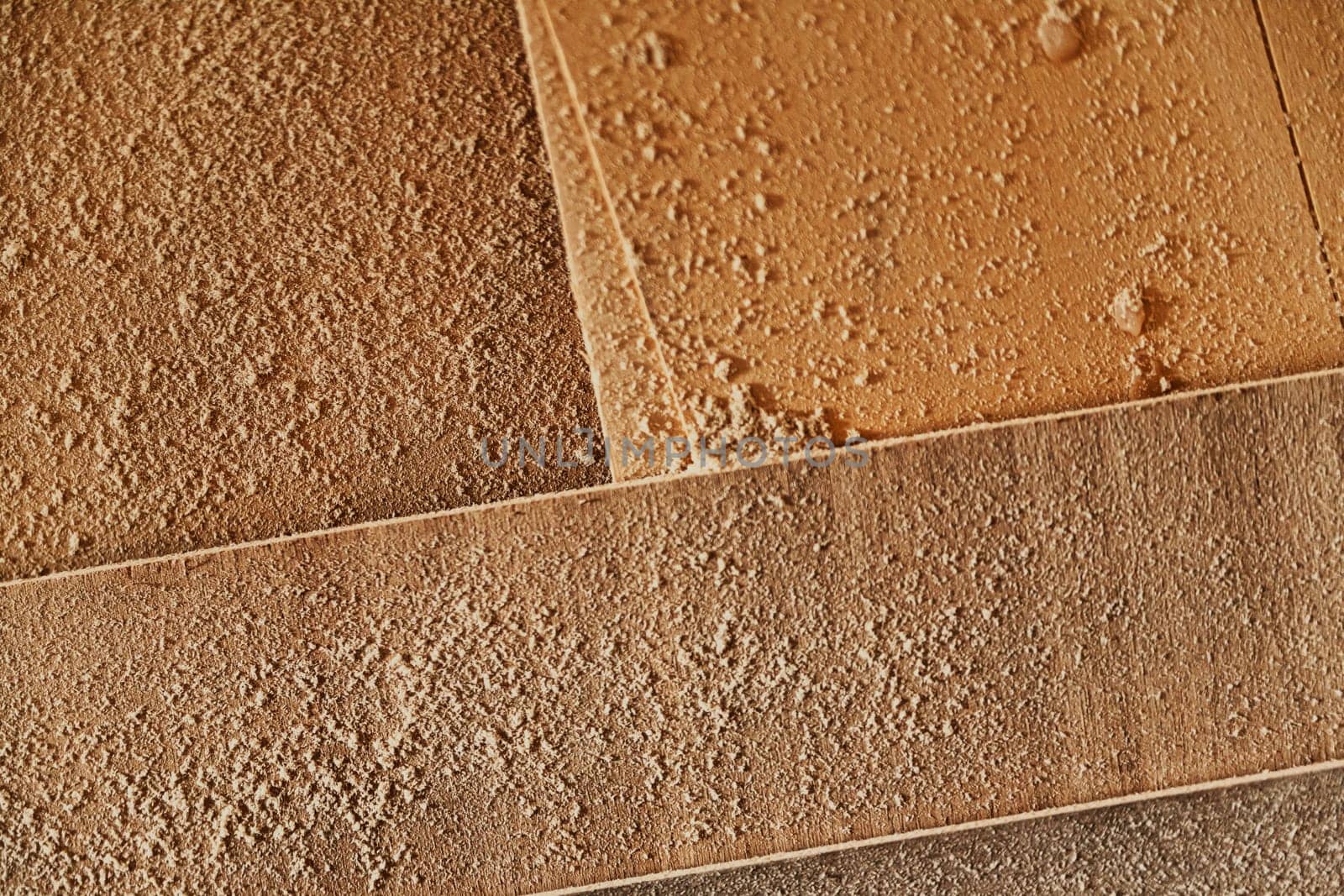 Fresh sawdust lying on panels of wood in a workshop viewed from above in a full frame texture