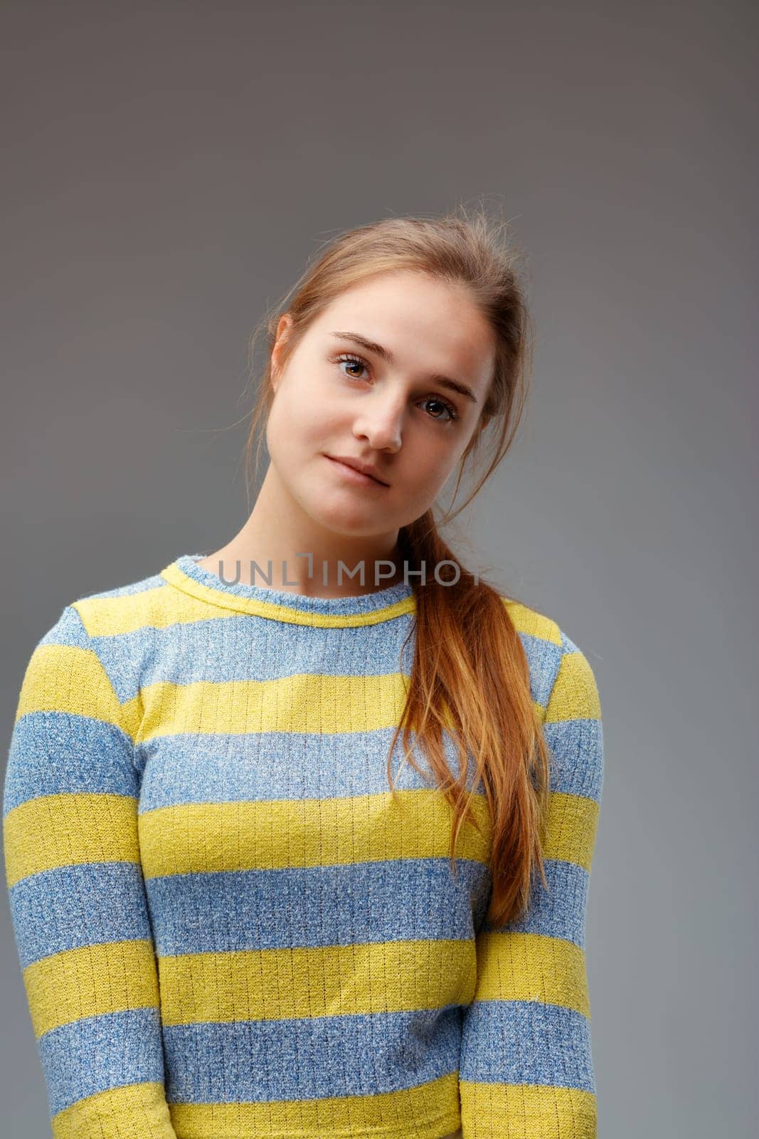 portrait of a young woman with her head tilted, as if waiting, in the style of manga and anime, wearing a striped sweater and has an indecipherable serene expression