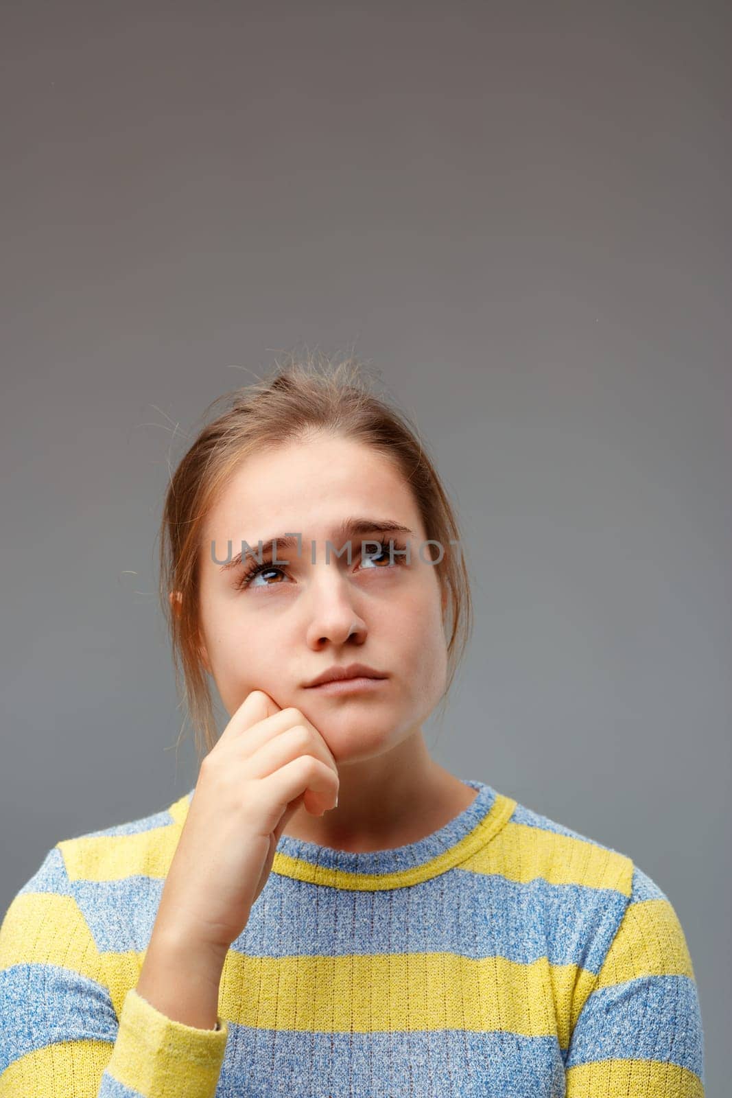 Sad thinking expression. Young woman mulls over or remembers the past, perhaps she has unrealizable expectations in the future in which she still believes little.