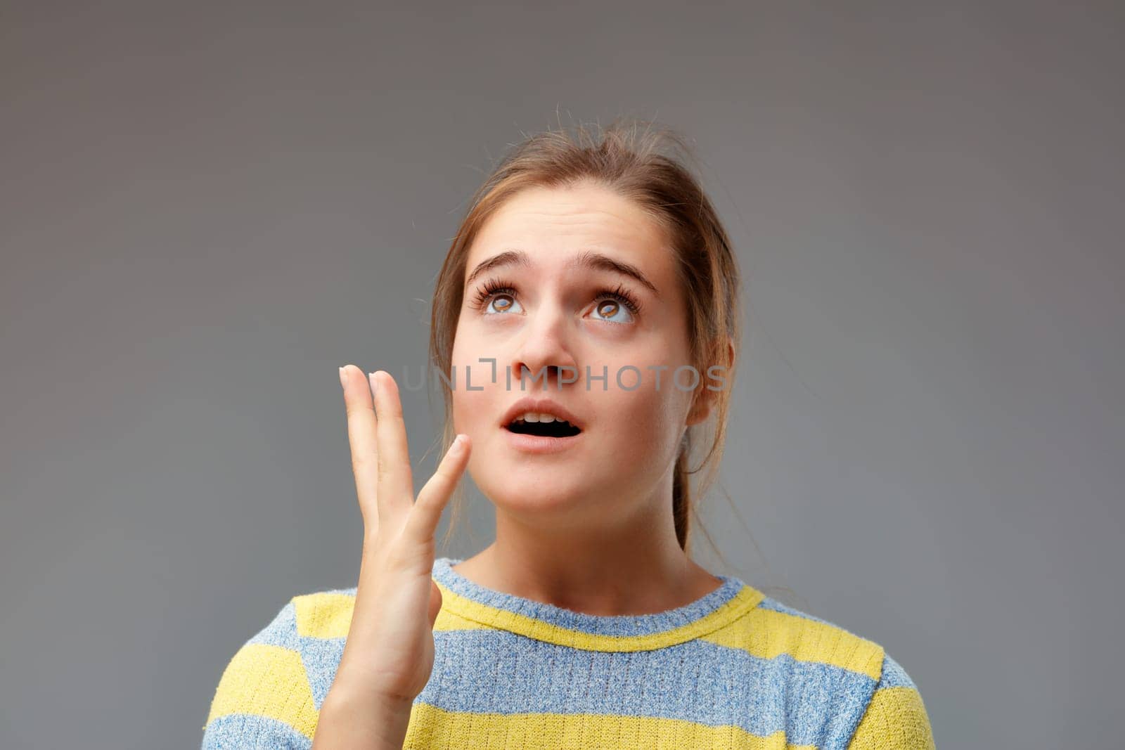 Emphatic and theatrical gesture of a young woman who had a revelation, perhaps an idea. But she may also have forgotten the gas on.