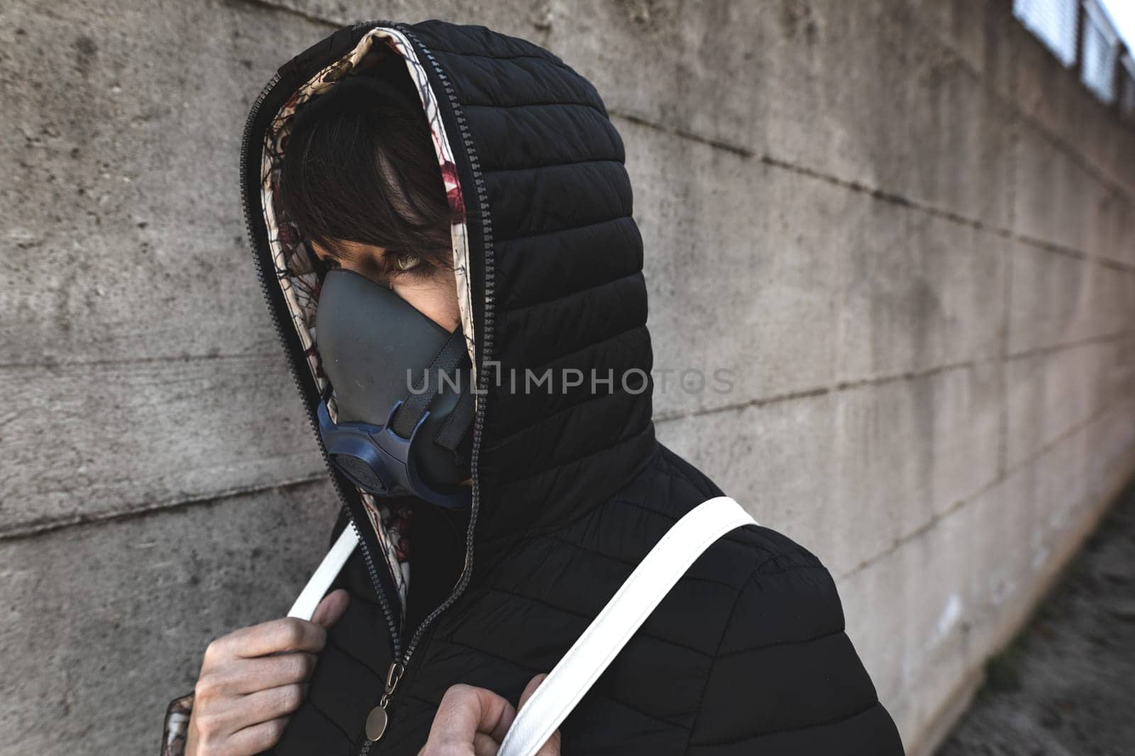 woman with a gas mask walking on the city streets surviving a corona virus pandemic or post atomic world