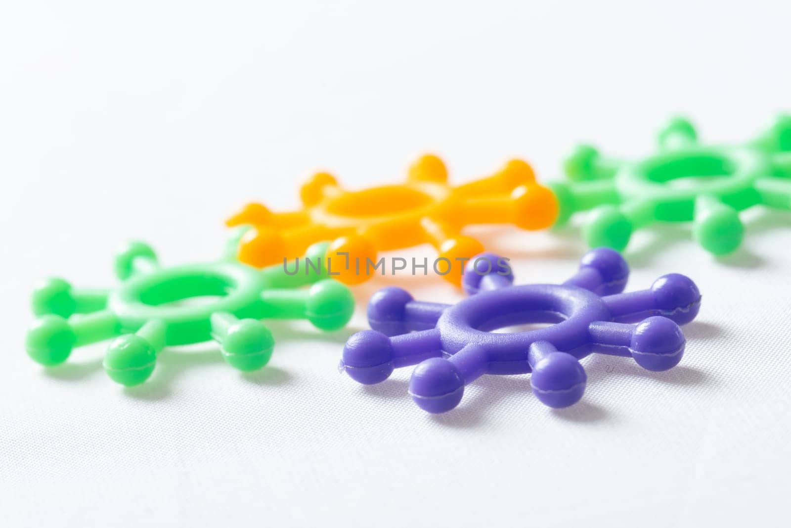 Plastic models of the coronavirus molecule scattered on a white background viewed low angle with copy space above and below for Covid-19 concepts