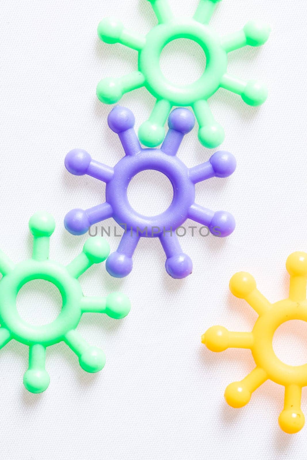 Four colorful toy models o the coronavirus molecules arranged on a white background with copy space conceptual of the Covid-19 global pandemic