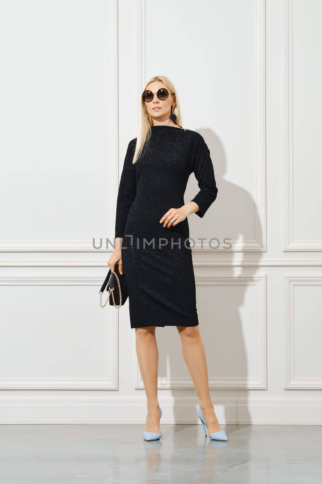 Casual office female outfit. Classy woman in sunglasses and tight black dress