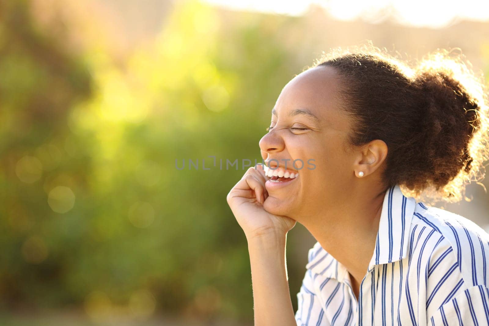 Funny black woman resting and laughing in a park