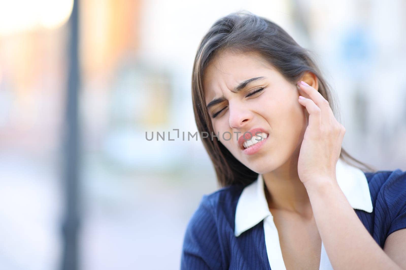 Stressed woman complaining suffering earache in the street