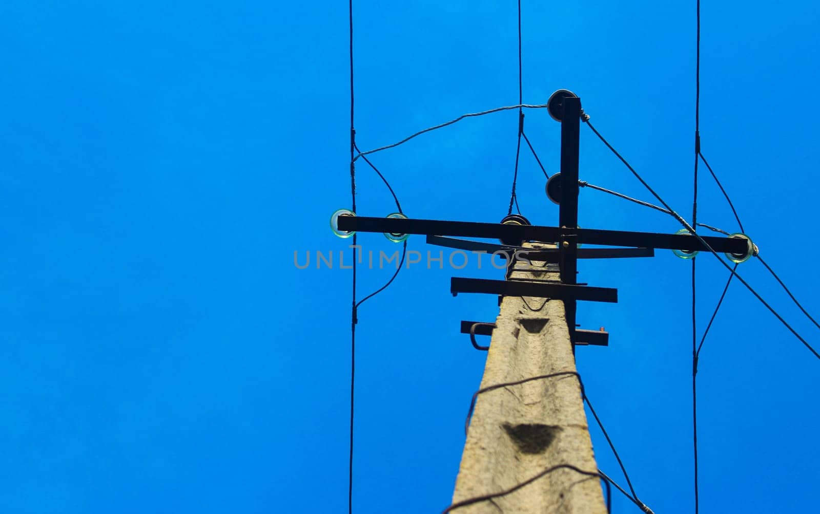 Electricity post in blue sky. Outdoor view. Electrical powered pillar. Power lines - Power Transmission Lines and blue sky. Electrical pole.