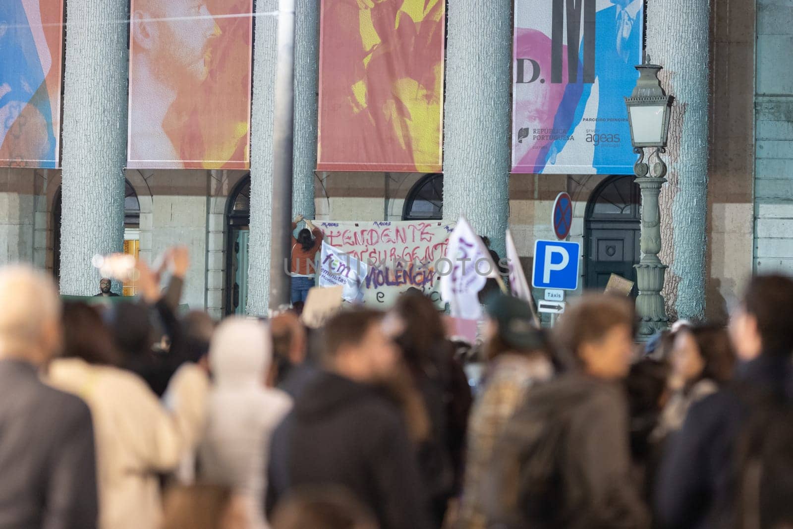 PORTUGAL, LISBON 11-25-2022: the March for the End of Violence Against Women - women hang a poster on poles. Mid shot