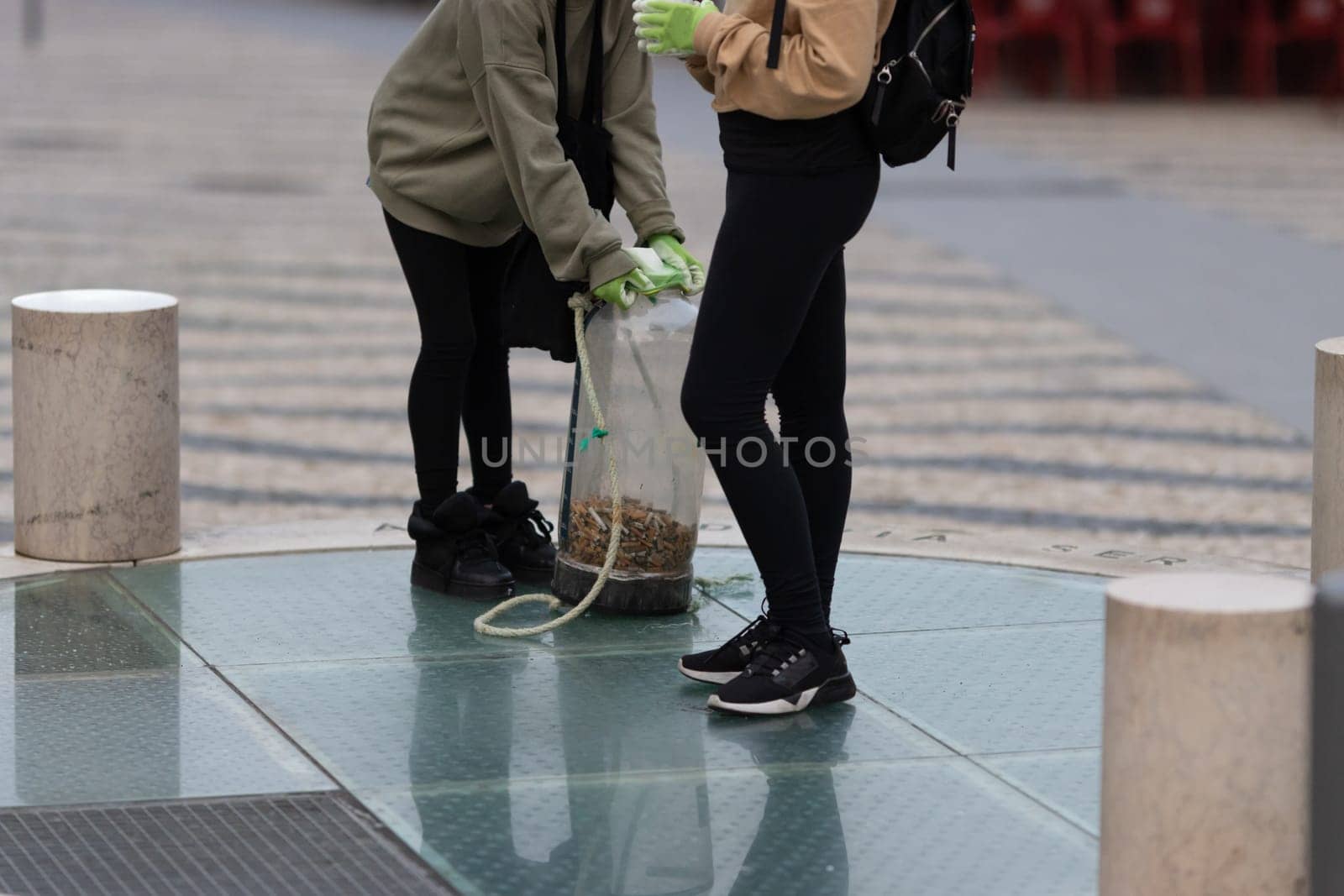 Activists collect cigarette bulls dropped on the street. Mid shot