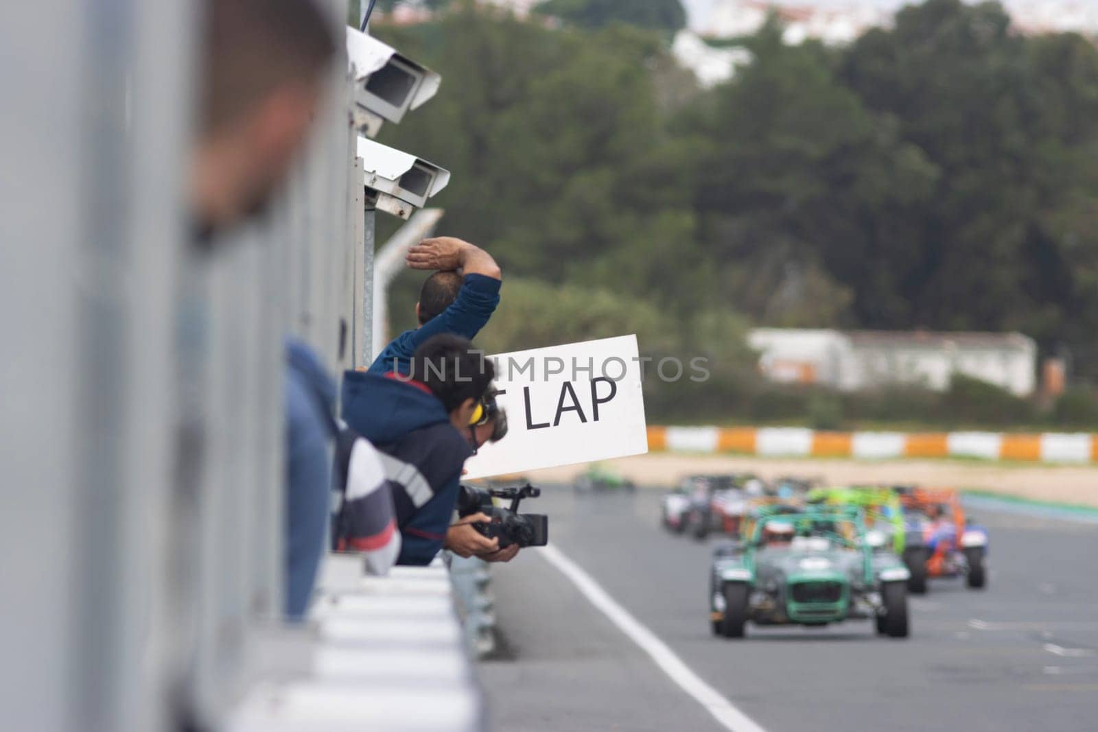 Kart racing - a man holding a placard with lap counting. Mid shot