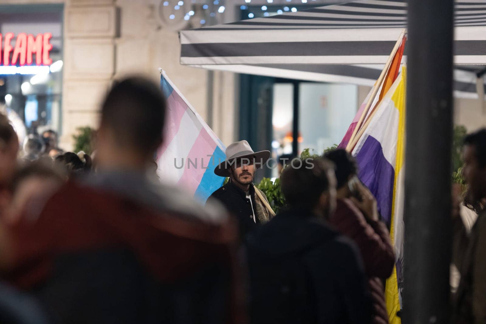 PORTUGAL, LISBON 11-25-2022: the March for the End of Violence Against Women - a man holding transgender flag. Mid shot