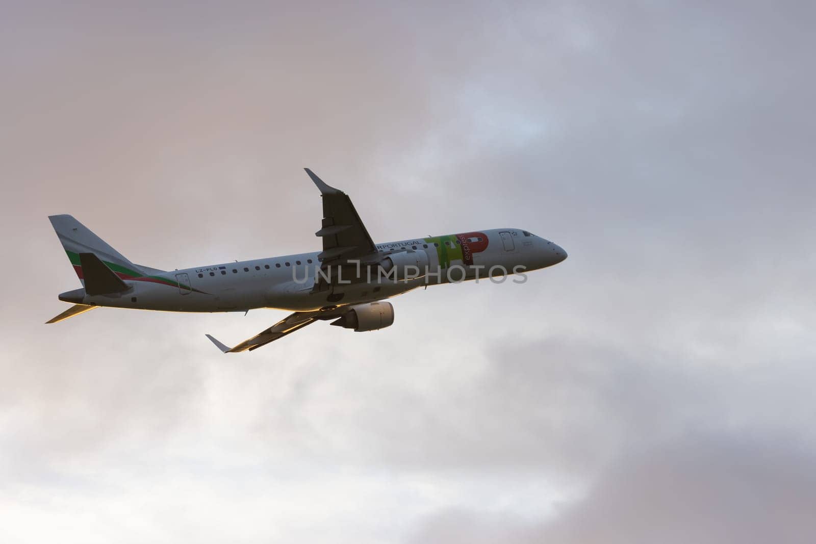 30 November 2022 PORTUGAL, LISBON: an AIRPORTUGAL airplane gains altitude at early sunset. Mid shot
